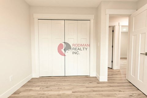 A room with a white door and Rodman Realty Inc. logo on it.
