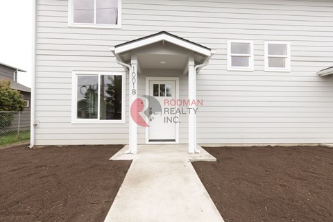 A house with a sign that says "Rodman Realty Inc." in front of it.