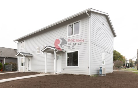 A small building with a sign that says Rodman Realty Inc. on it.