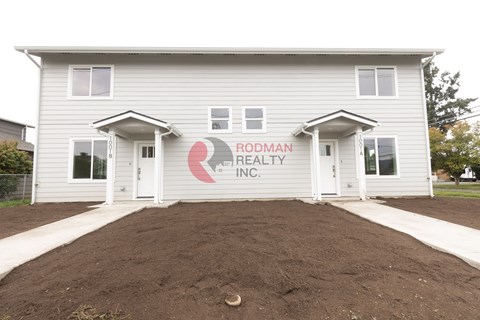 A house with a sign that says Rodman Realty Inc. on it.