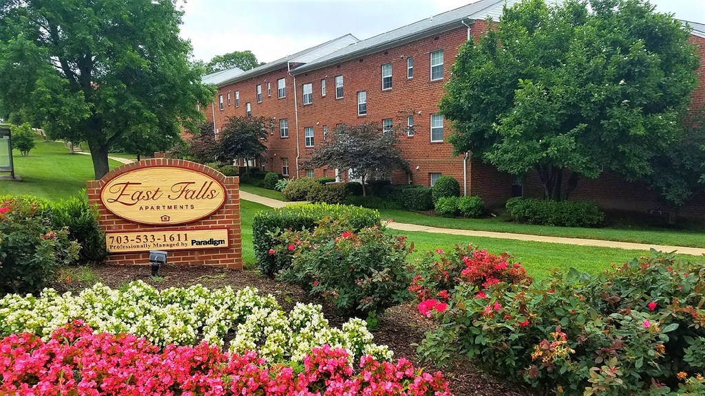 A brick building with a sign that says "East Falls Apartments" in front of it.