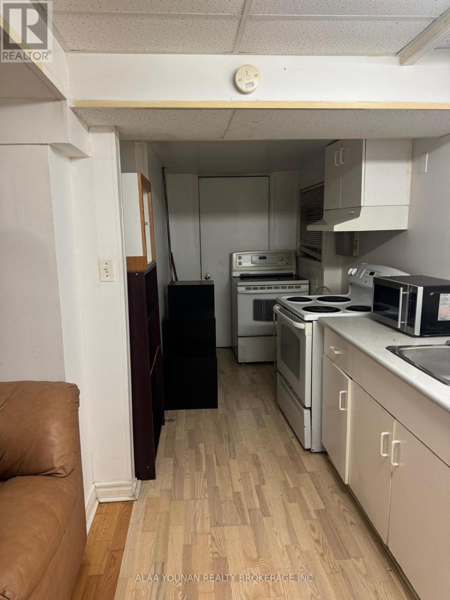 A kitchen with white cabinets and a wooden floor.