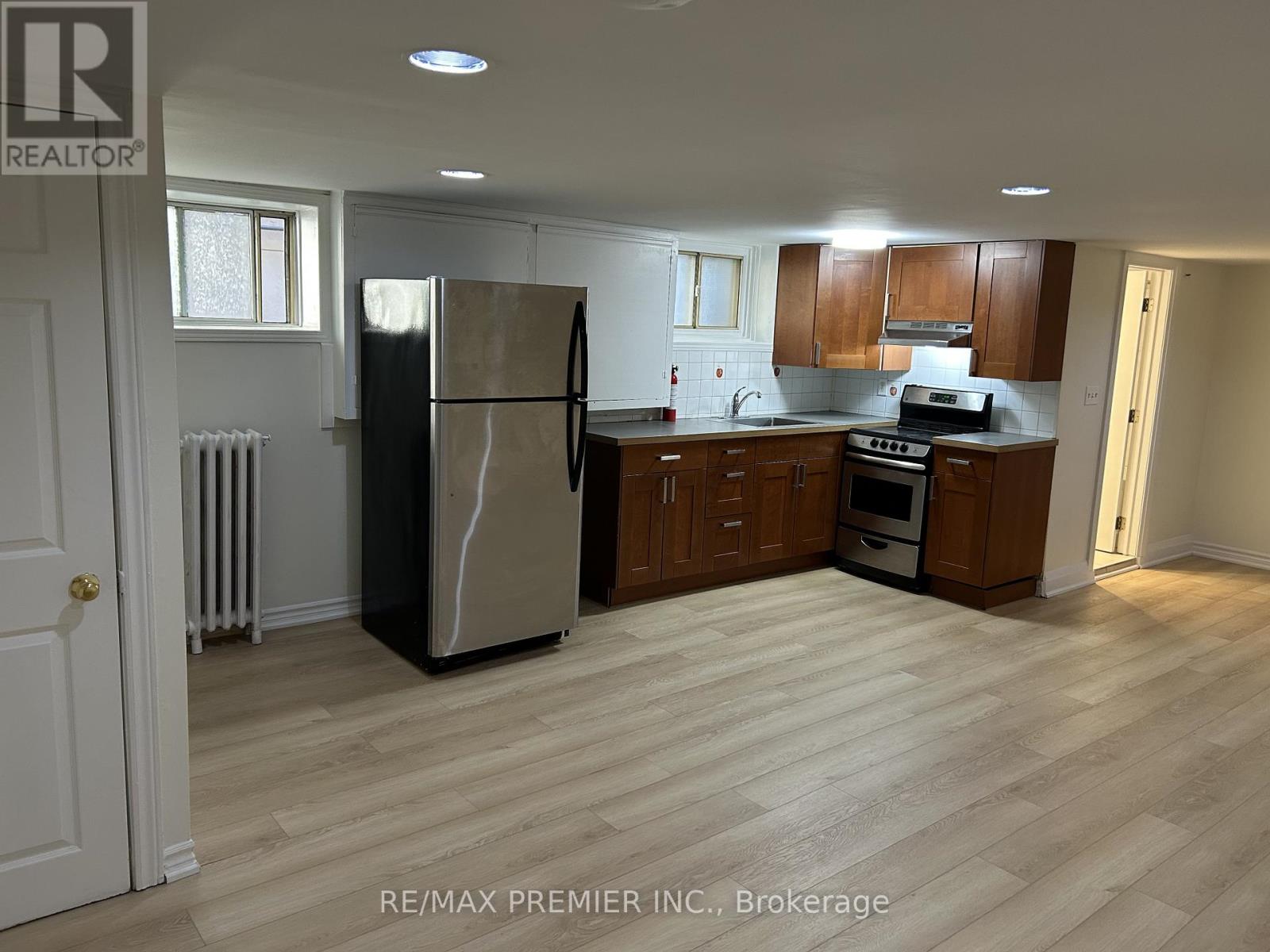 A kitchen with a refrigerator, oven, and microwave.