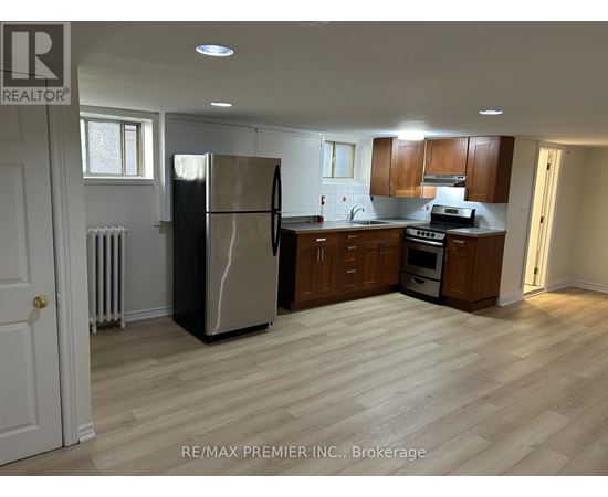 A kitchen with a refrigerator, oven, and microwave.