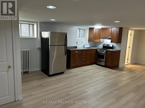 A kitchen with a refrigerator, oven, and microwave.