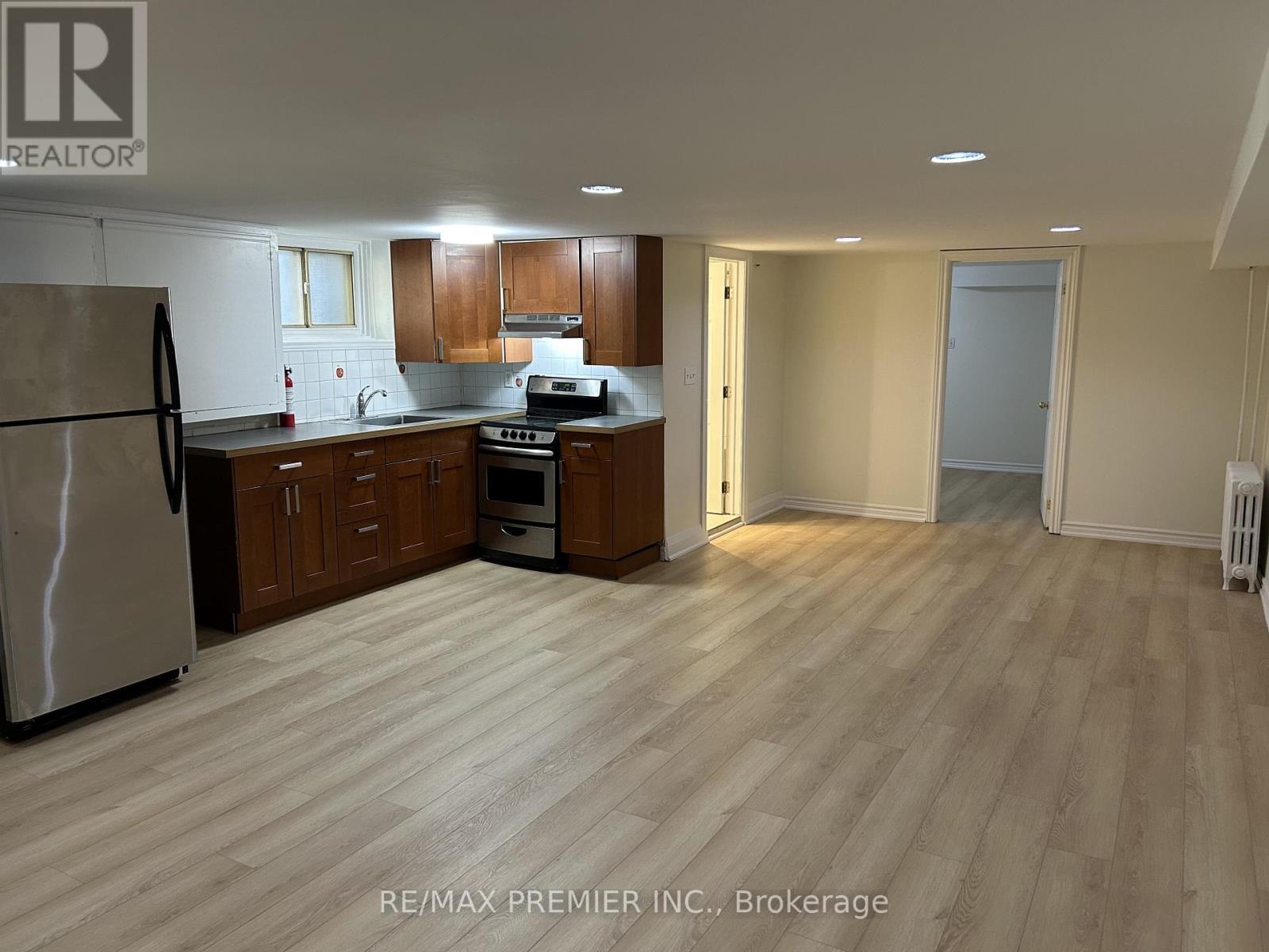 A kitchen with wooden floors and a refrigerator.