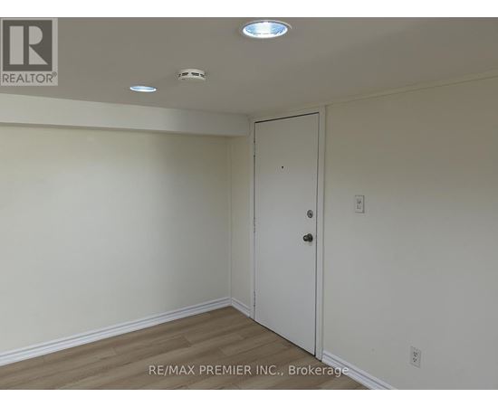 A room with a white door and a white ceiling with lights.