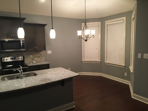 A kitchen with a granite countertop and a chandelier.