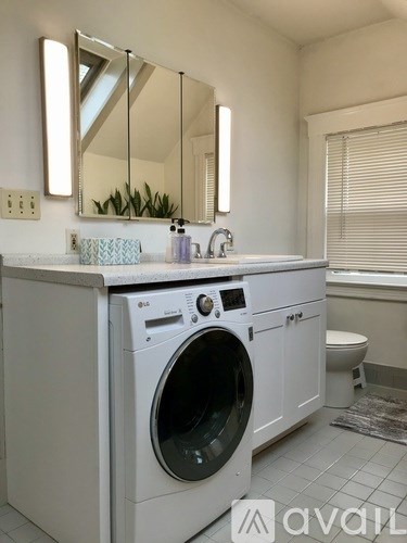 A white washing machine and dryer in a bathroom.