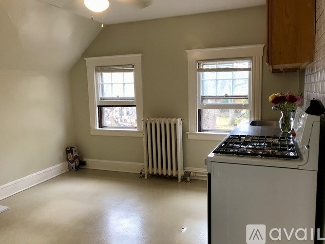 A kitchen with a stove, a window, and a radiator.