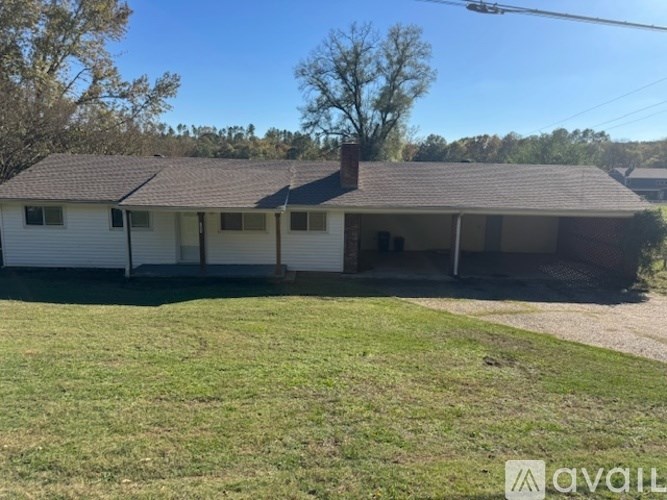 A white house with a brown roof and a brown chimney.