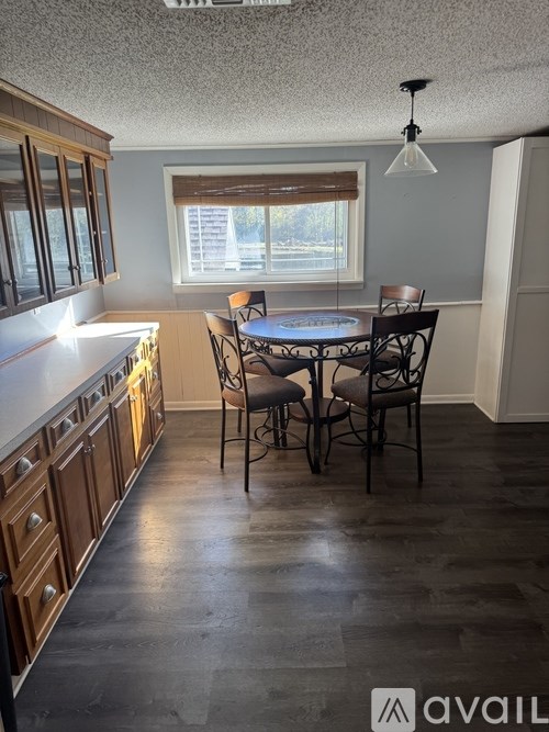A kitchen with a table and chairs in front of a window.
