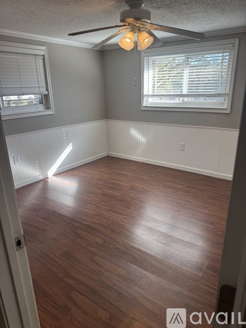 A room with wooden flooring and a ceiling fan.