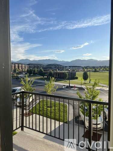 A balcony view of a residential area with mountains in the distance.