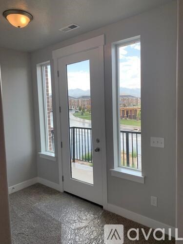 A room with a view of a balcony and buildings outside.