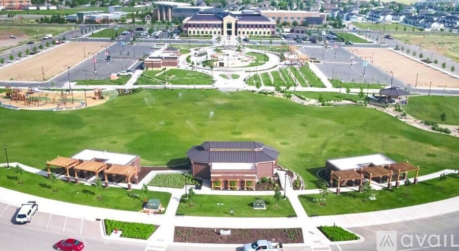 An aerial view of a large building surrounded by a green lawn and a parking lot.