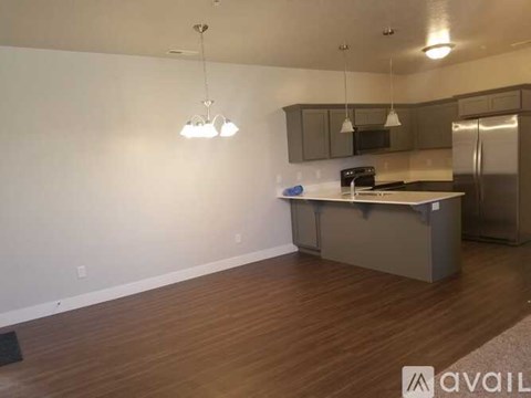 A kitchen with a refrigerator, microwave, and oven.