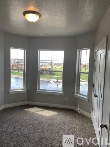 A room with a carpeted floor and a door on the right.