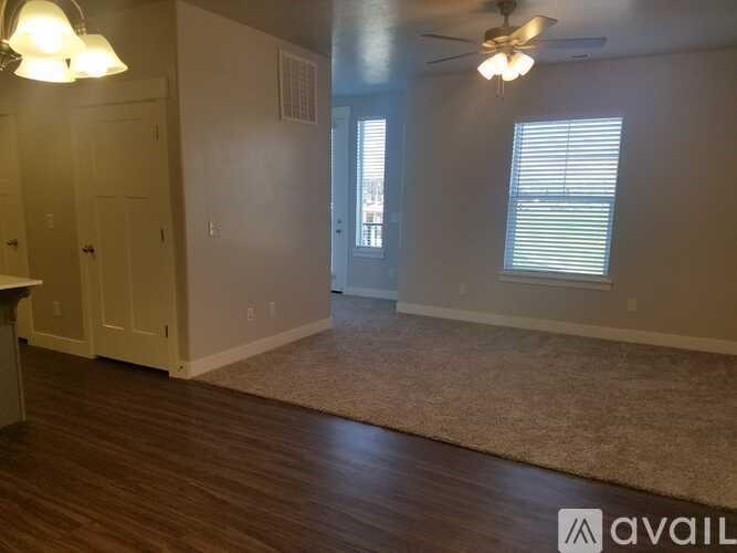 A room with a rug on the floor and a ceiling fan.