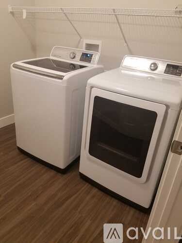 Two white front loading washing machines in a laundry room.