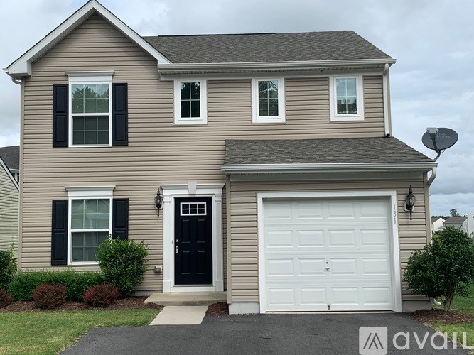 A two-story house with a black front door and white garage door.