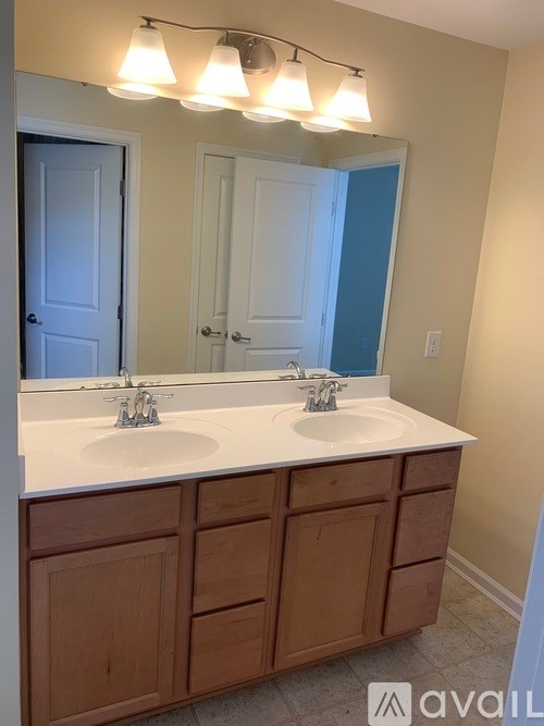 A bathroom with two sinks and a large mirror.