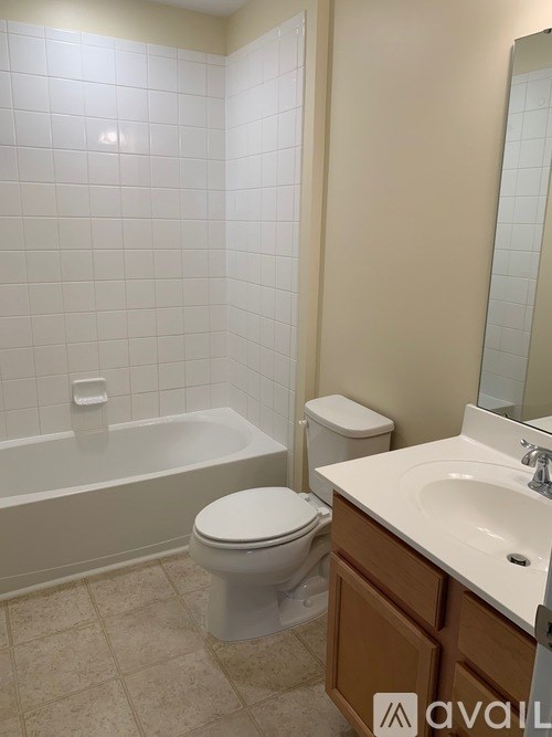 A white toilet sits next to a bathtub in a bathroom.