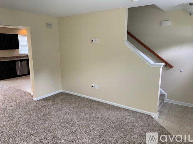 A room with beige walls and carpeted floor.