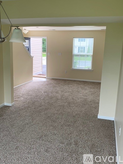 A room with a carpeted floor and a window.