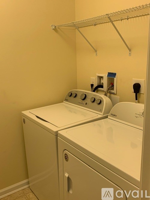 A wall-mounted clothes dryer is on the right and a washer and dryer are on the left.