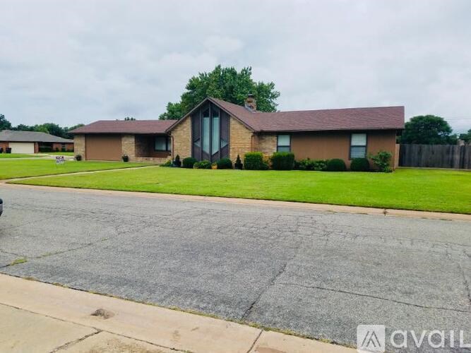 A house with a brown roof and a driveway in front.