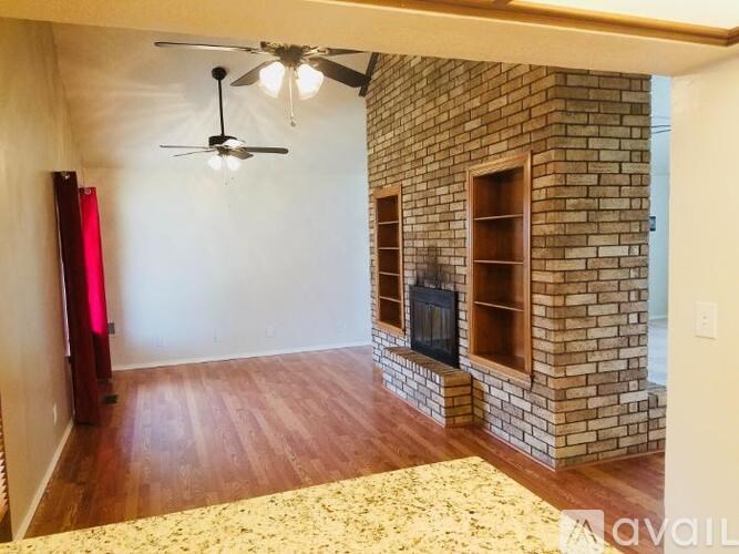 A room with a fireplace and a ceiling fan.