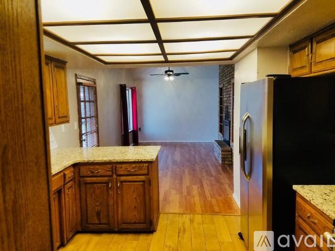 A kitchen with wooden cabinets and a black refrigerator.