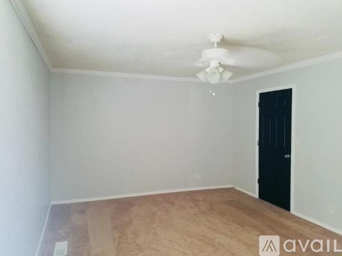 A room with a black door and a ceiling fan.