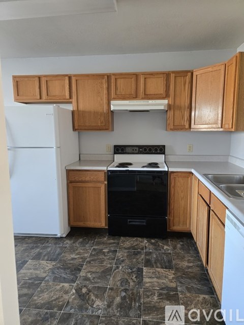 A kitchen with wooden cabinets and a black stove top oven.
