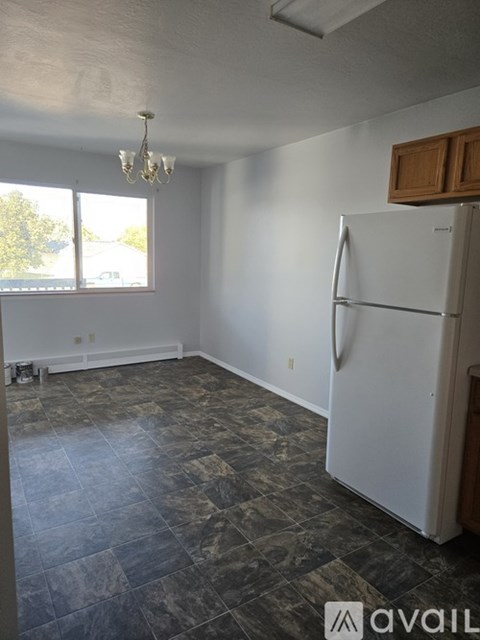 A kitchen with a white refrigerator and a chandelier.
