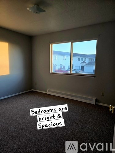 A room with a window showing a view of houses outside.