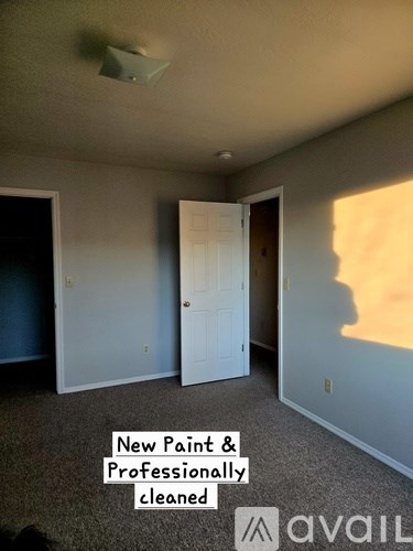 A room with a white door and a sign that says New Paint & Professionally cleaned.