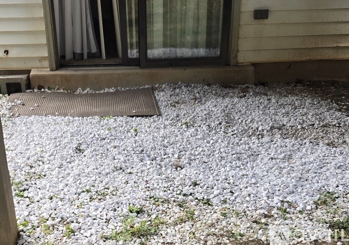 A sliding glass door with a view of a green lawn outside.