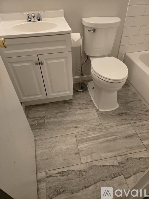 A bathroom with a toilet and sink is visible through a glass door.