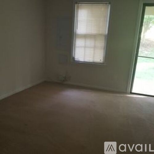 A room with a window and a door leading outside.