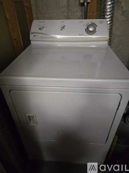 A white dryer is sitting in a room.