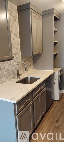 A kitchen with a sink and a washing machine.