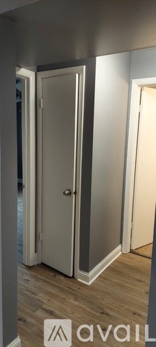 A white door is closed and there is a logo on the bottom right.