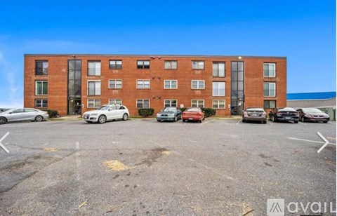 A parking lot with cars and a building in the background.