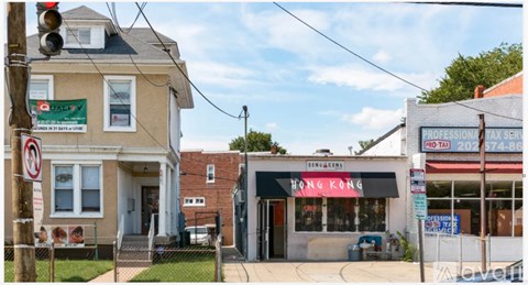 A street view with a no parking sign and a building with a red sign that says Hong Kong.