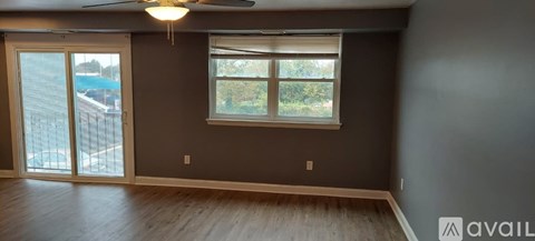 A room with a ceiling fan and a window with blinds.
