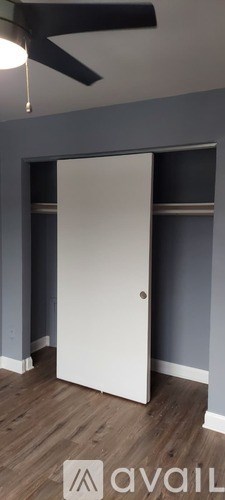 A white door is in a room with a ceiling fan.