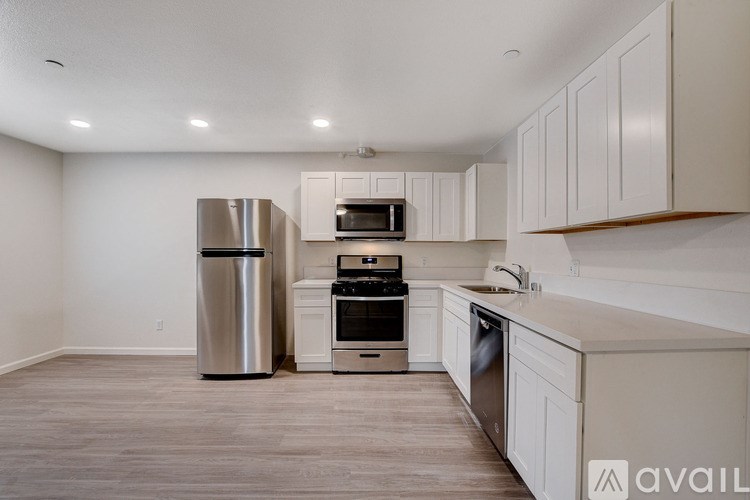 A kitchen with a stainless steel refrigerator, oven, and microwave.