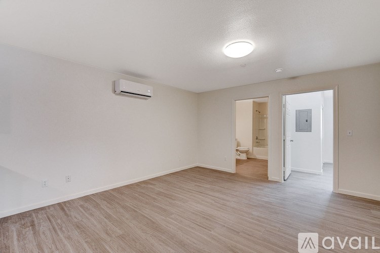 A spacious room with a light on the ceiling and a wall-mounted air conditioner unit.